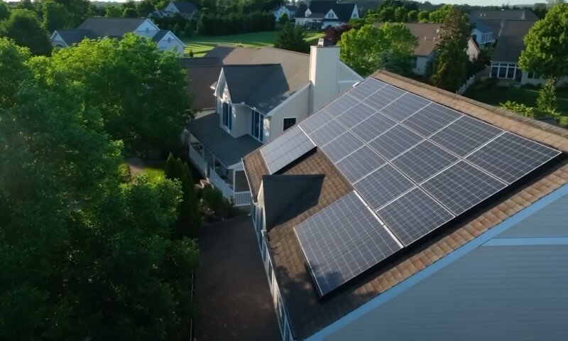 Aerial view of a house featuring solar panels installed on its roof